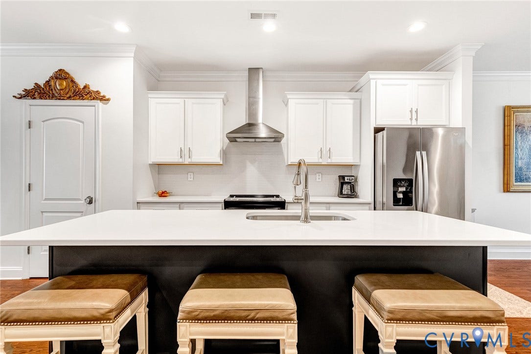 14379 Michaux Village Drive, Winterfield Park, Midlothian, VA 23113 Kitchen featuring a large island with a solid surface countertop, stainless steel appliances, white cabinetry, and a subway tile backsplash
