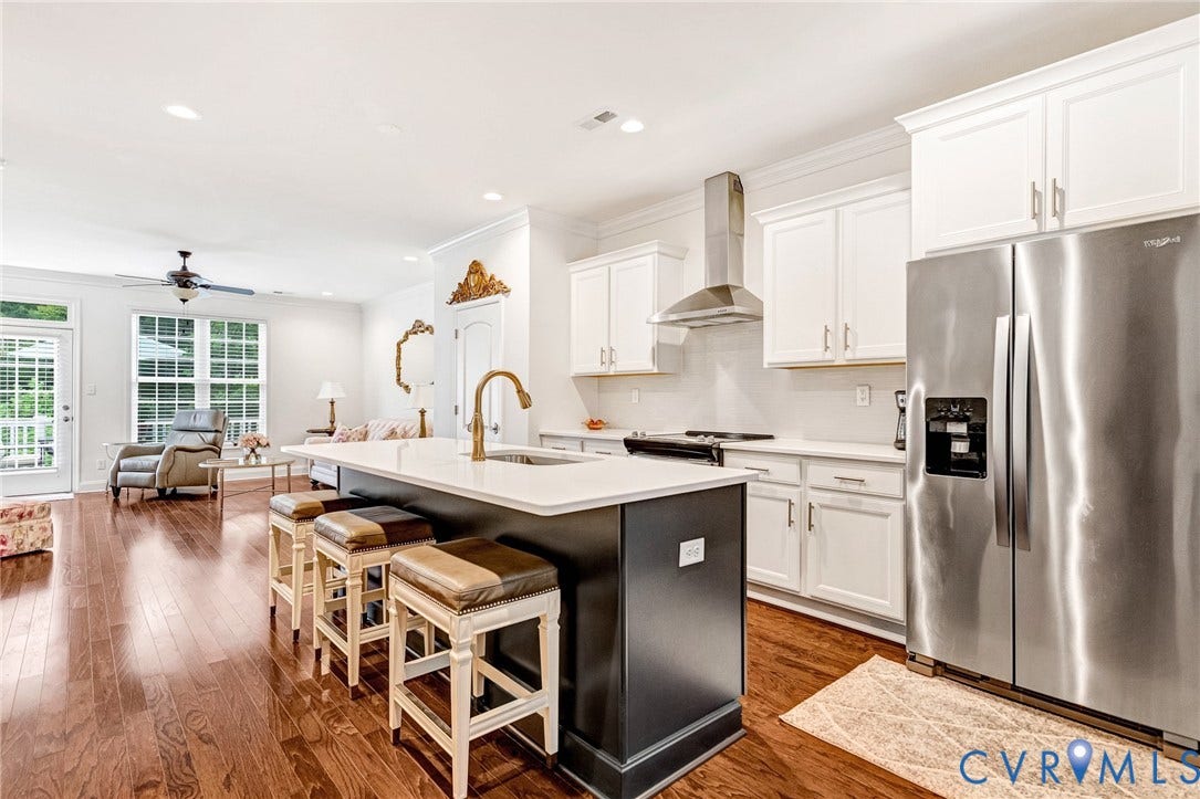 14379 Michaux Village Drive, Winterfield Park, Midlothian, VA 23113 Open-concept kitchen featuring a large island with seating, stainless steel appliances, white cabinetry, and wood-finish flooring