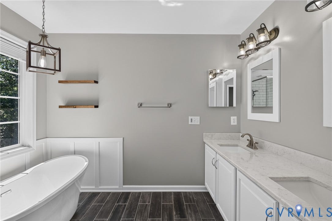 381 Shorewood Drive, Shorewood, Mineral, VA 23117 Spacious bathroom featuring a freestanding soaking tub, dual vanity with undermount sinks, and wood-finish plank flooring