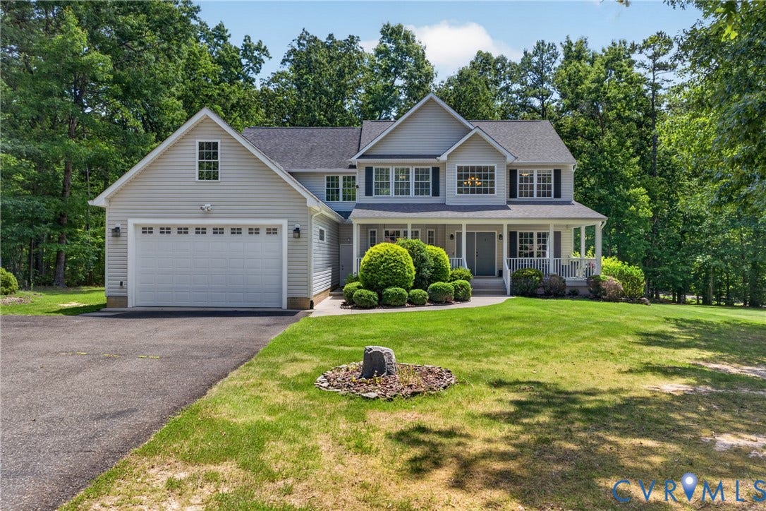 381 Shorewood Drive, Shorewood, Mineral, VA 23117 Two-story residence featuring light gray siding, a covered front porch with white railings, and an attached two-car garage