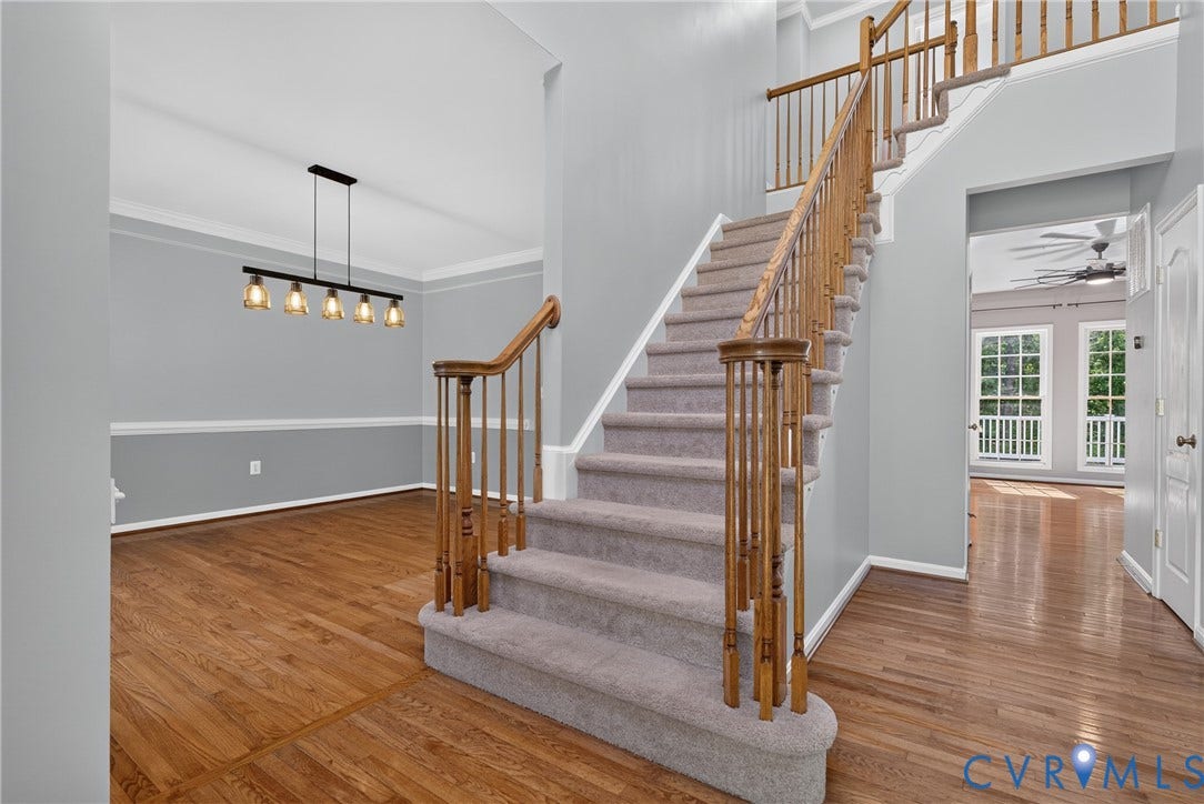 381 Shorewood Drive, Shorewood, Mineral, VA 23117 Entry foyer with wood-finish flooring featuring a carpeted staircase with wood banister and balusters