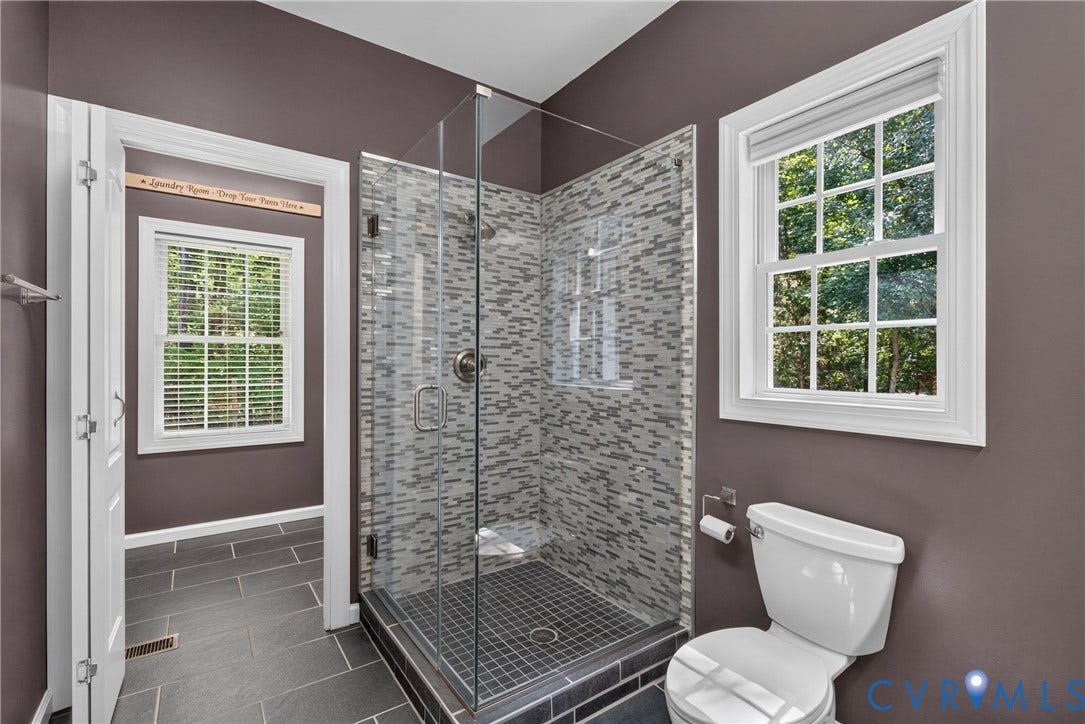 381 Shorewood Drive, Shorewood, Mineral, VA 23117 Glass-enclosed shower with mosaic tile surround, featuring a built-in seat and a dark-tiled shower pan