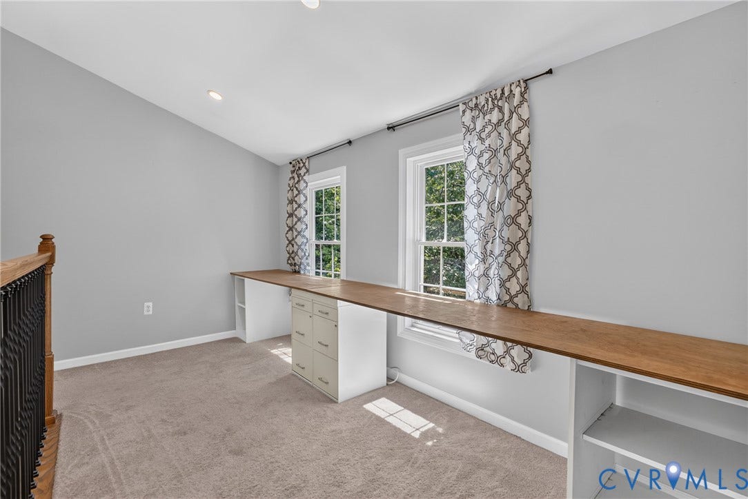381 Shorewood Drive, Shorewood, Mineral, VA 23117 Loft space at the top of the rear stairwell landing -featuring two windows, an extended built-in wood-finish desk, recessed lighting, and carpet flooring