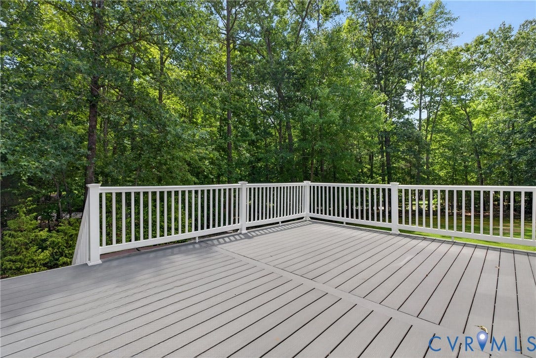 381 Shorewood Drive, Shorewood, Mineral, VA 23117 Spacious outdoor deck with gray composite decking and white railing, surrounded by a lush tree canopy