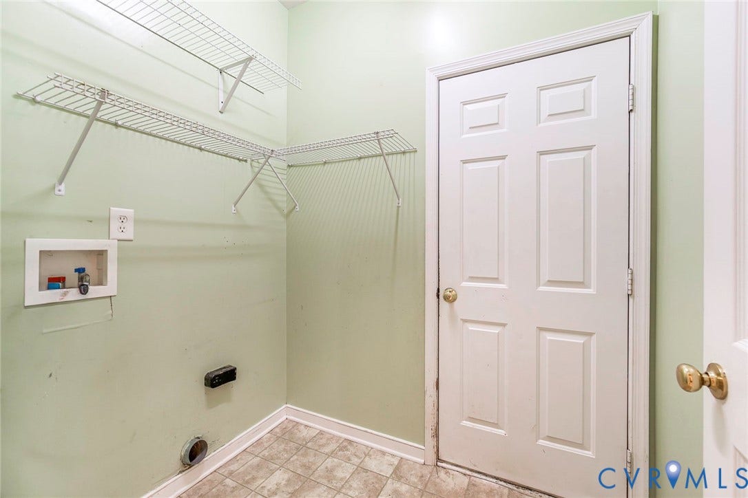 Utility area featuring wire shelving, a six-panel interior door, and a utility sink hookup