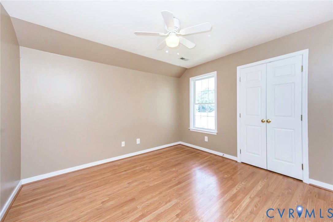 Room featuring wood-finish flooring, neutral wall tones, and white trim