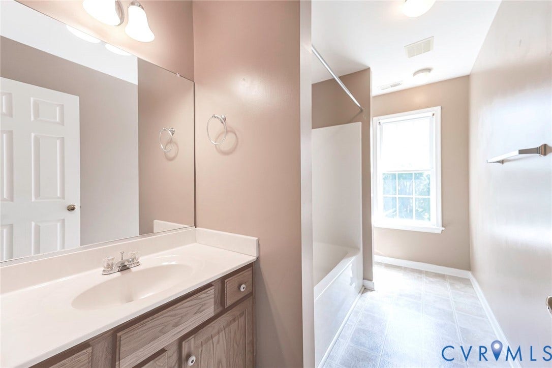 Bathroom vanity with an integrated sink, polished chrome faucet, and wood-finish cabinetry