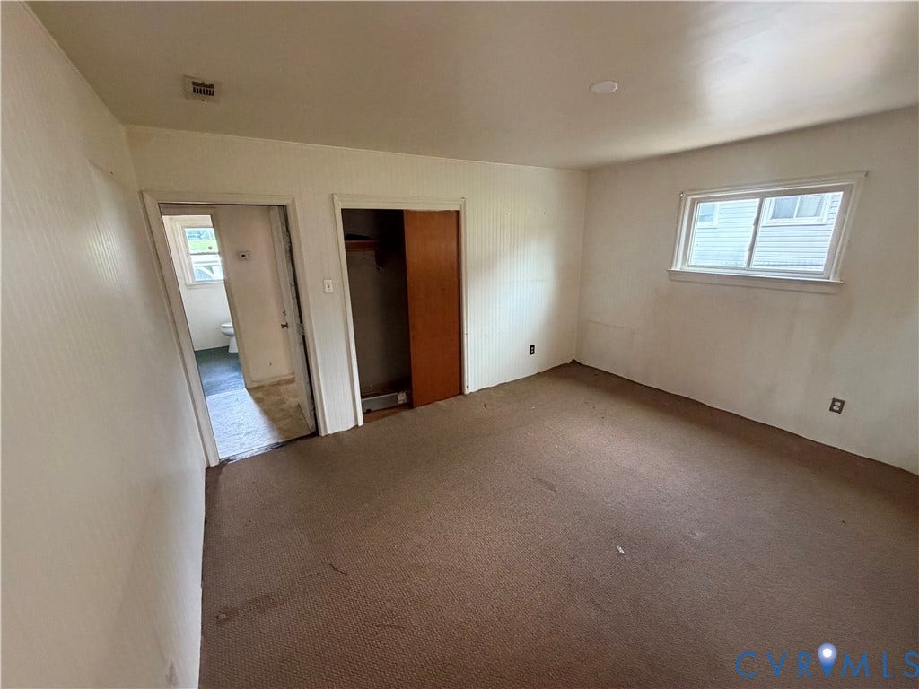 2206 Lancers Boulevard, Richmond, VA 23224 Carpeted room featuring a window with white trim, a recessed ceiling light, and an open closet with a wood-finish sliding door