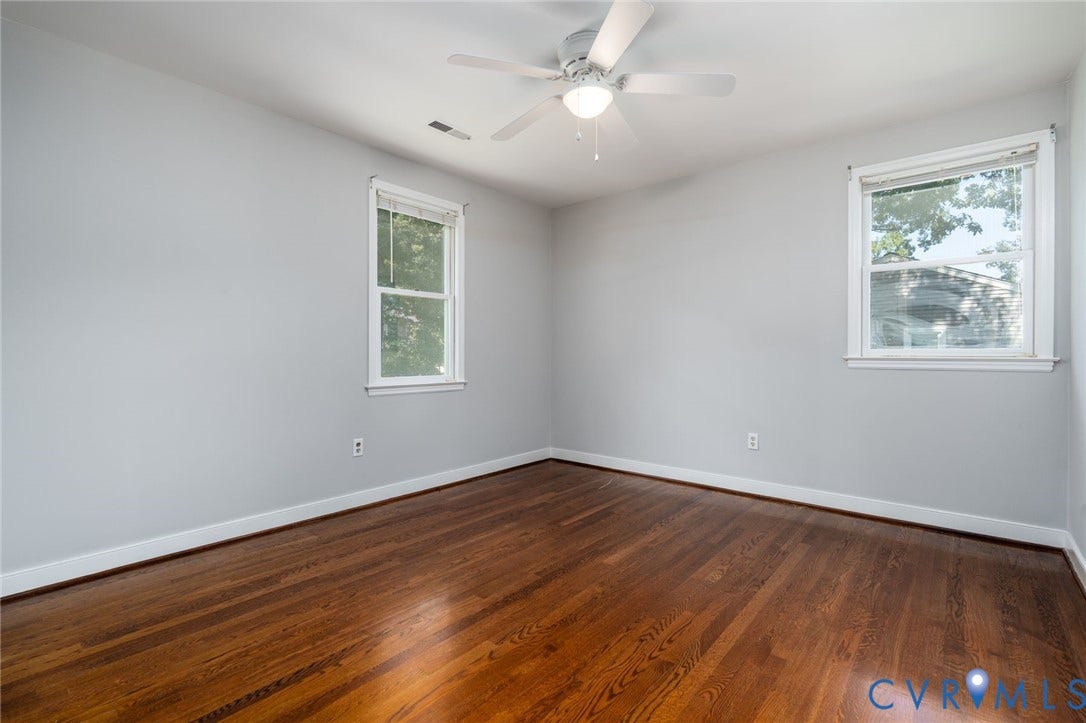 14613 Gimbel Drive, Chester, VA 23836 Hardwood flooring, light gray walls, two double-hung windows, and a ceiling fan with integrated lighting