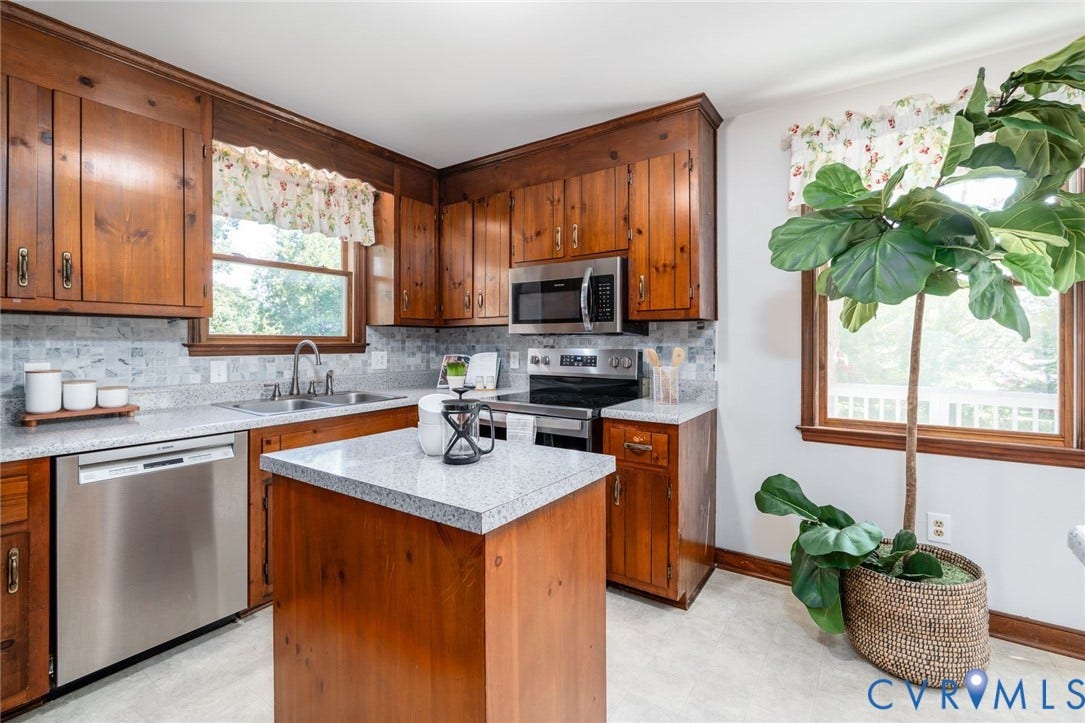 14613 Gimbel Drive, Chester, VA 23836 Hardwood cabinetry with stainless steel appliances, a kitchen island, and light-toned countertops