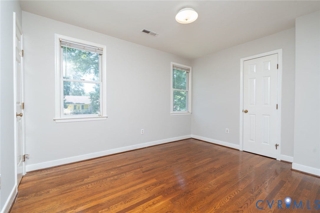14613 Gimbel Drive, Chester, VA 23836 Hardwood flooring throughout, with two windows offering natural light, two solid doors, and a ceiling-mounted light fixture