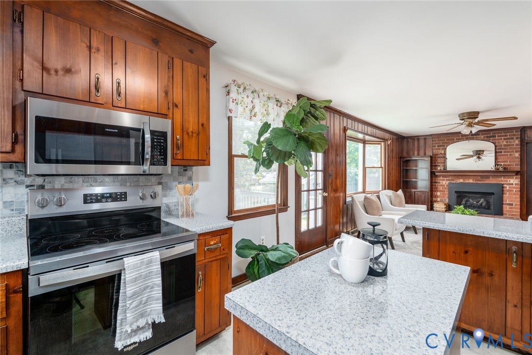 14613 Gimbel Drive, Chester, VA 23836 Stainless steel appliances, wood cabinetry, stone countertops, brick fireplace, and a ceiling fan