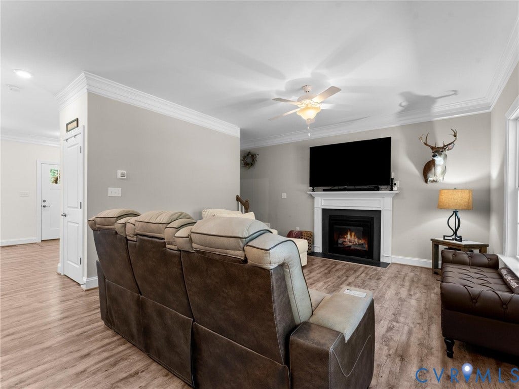 8200 Madeline Court, Strath Woods, Henrico, VA 23231 Living area featuring wood-finish flooring, a white mantel fireplace, and crown molding