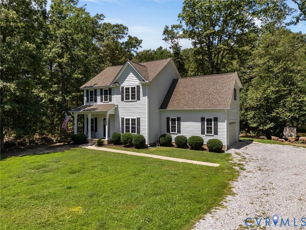 8200 Madeline Court, Strath Woods, Henrico, VA 23231 Two-story property featuring light-toned horizontal siding, a covered entry porch with columns, a two-car garage, and a gravel driveway
