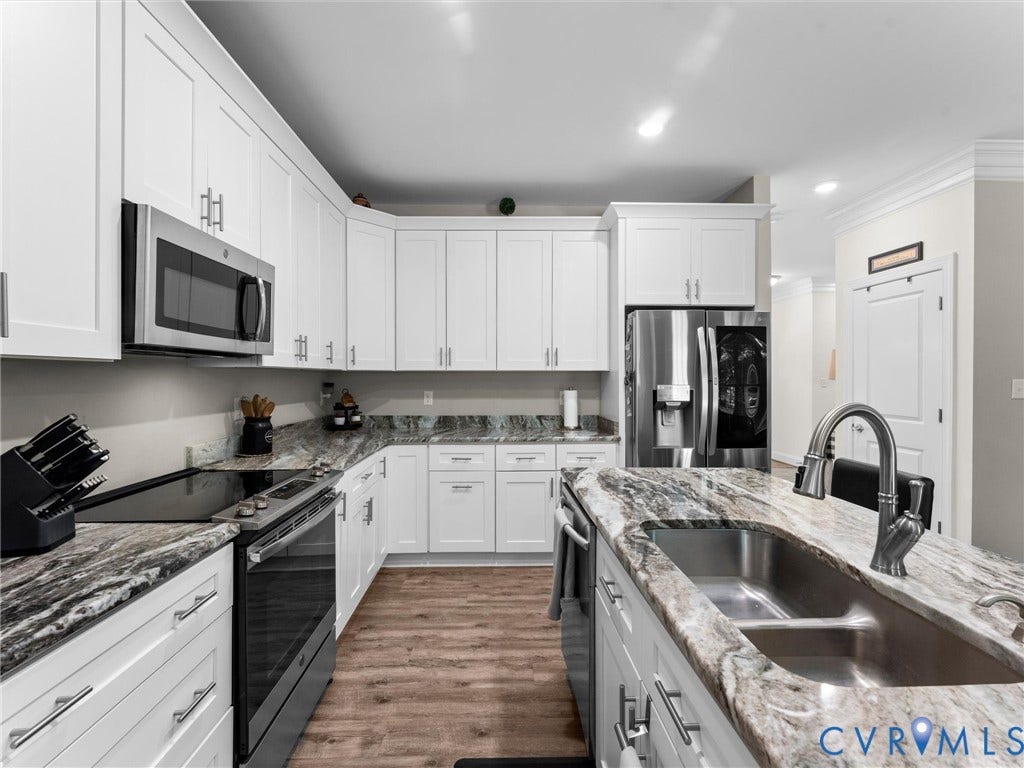 8200 Madeline Court, Strath Woods, Henrico, VA 23231 Kitchen featuring an island with a double basin sink, stainless steel appliances, white cabinetry with silver hardware, wood-finish flooring, and recessed lighting