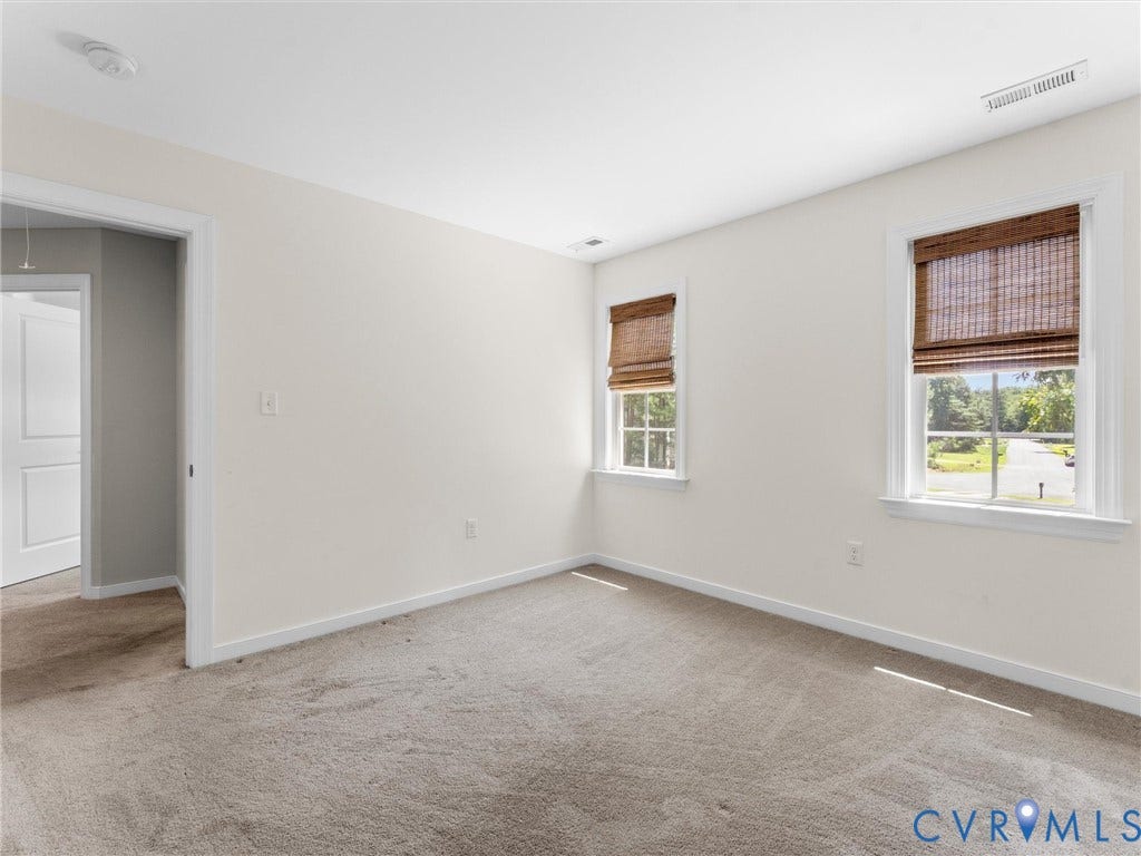 8200 Madeline Court, Strath Woods, Henrico, VA 23231 Carpeted room featuring two windows with woven wood shades, white trim, and a white ceiling with a visible vent