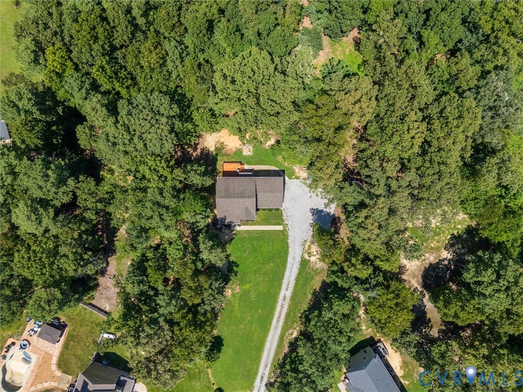 8200 Madeline Court, Strath Woods, Henrico, VA 23231 Private wooded setting featuring a main residence with a gabled roofline, an exterior deck, and a gravel driveway