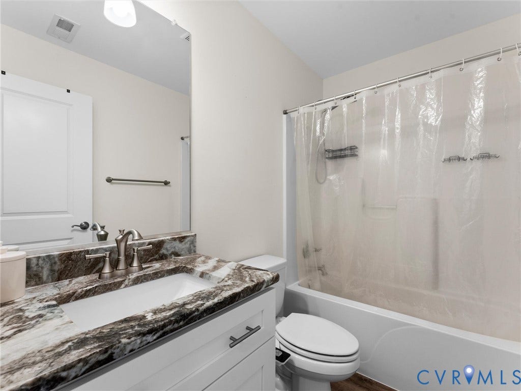 8200 Madeline Court, Strath Woods, Henrico, VA 23231 Bathroom featuring a vanity with a patterned countertop, undermount sink, brushed nickel faucet, full-width mirror, and a bathtub with an integrated shower