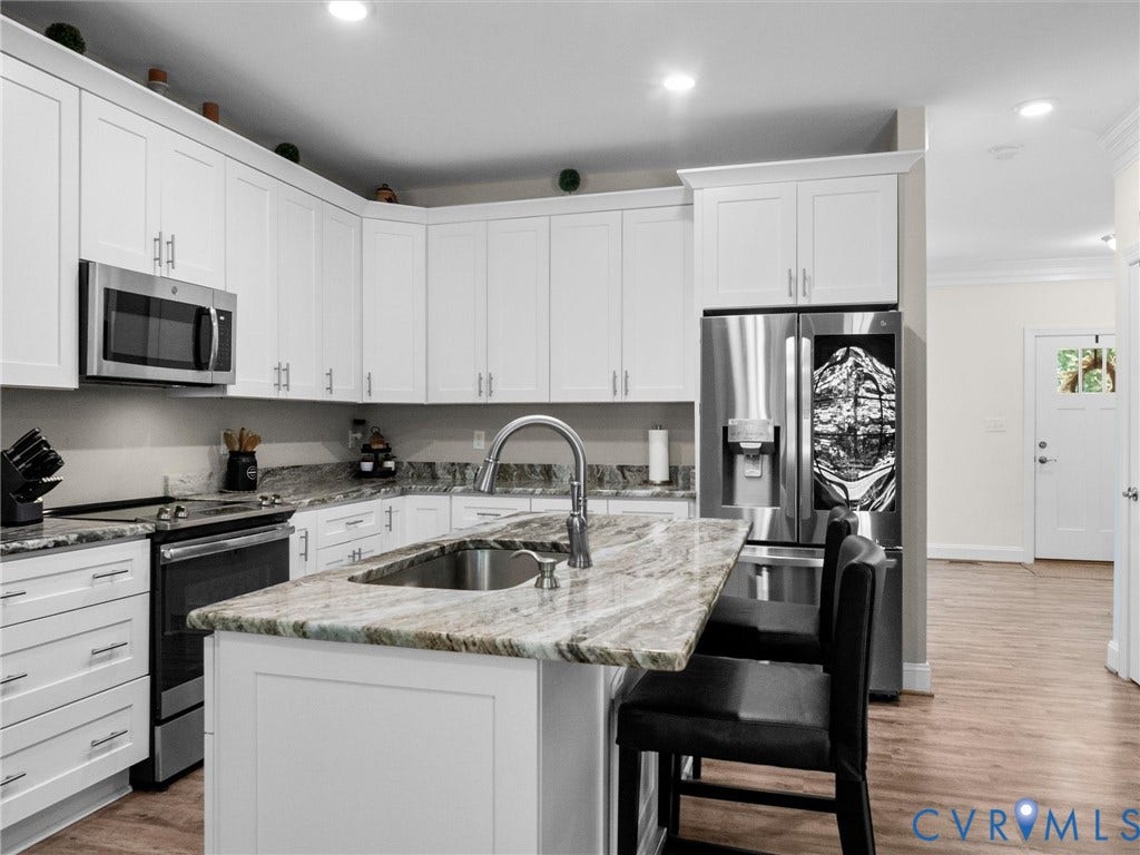 8200 Madeline Court, Strath Woods, Henrico, VA 23231 Modern kitchen featuring white shaker cabinetry, stainless steel appliances, and wood-finish flooring