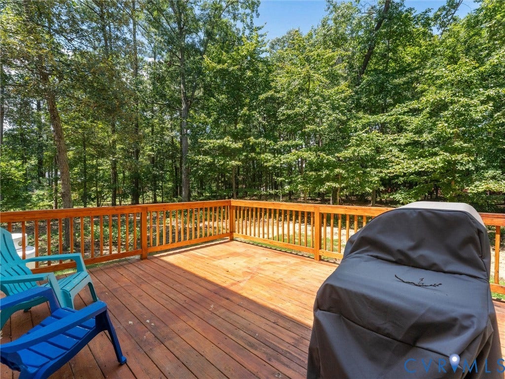 8200 Madeline Court, Strath Woods, Henrico, VA 23231 Expansive wood-finish deck with a natural wood railing, surrounded by mature trees