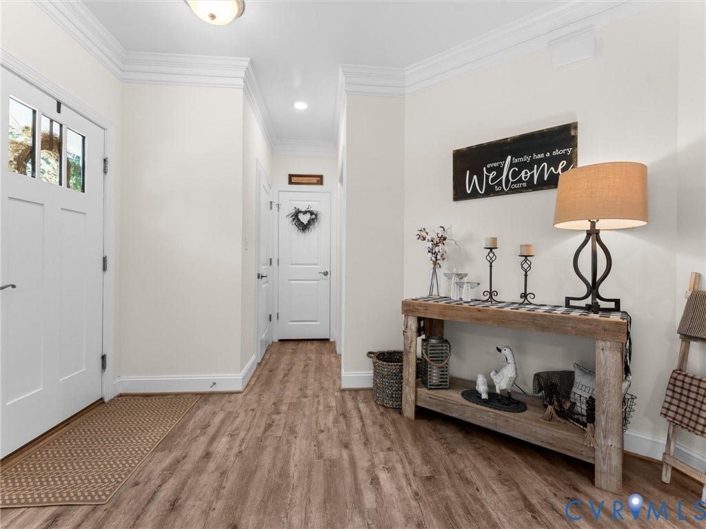 8200 Madeline Court, Strath Woods, Henrico, VA 23231 Entryway featuring wood-finish flooring, a white paneled door with glass inserts, and crown molding