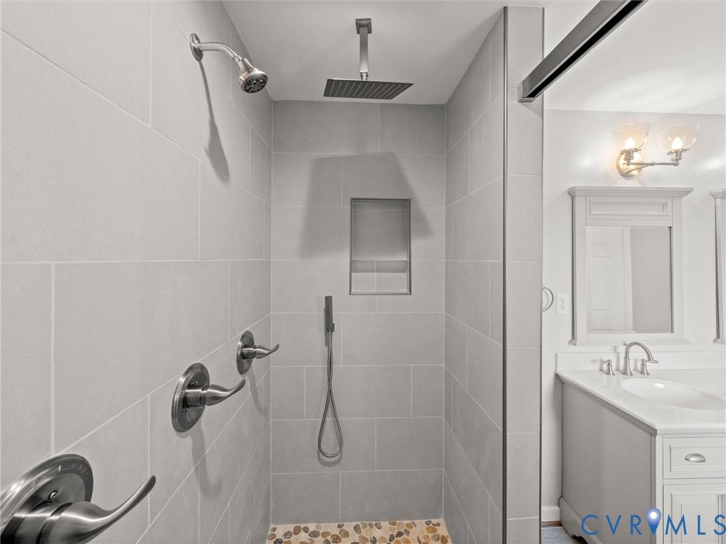 2224 Highland Drive, Powhatan, VA 23139 Shower featuring light-toned tile walls, a built-in niche, a rainfall showerhead, and a handheld shower attachment