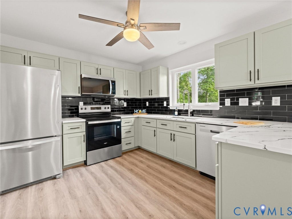 2224 Highland Drive, Powhatan, VA 23139 Kitchen featuring stainless steel appliances, light-toned cabinetry, a black subway tile backsplash, white countertops, and wood-finish flooring