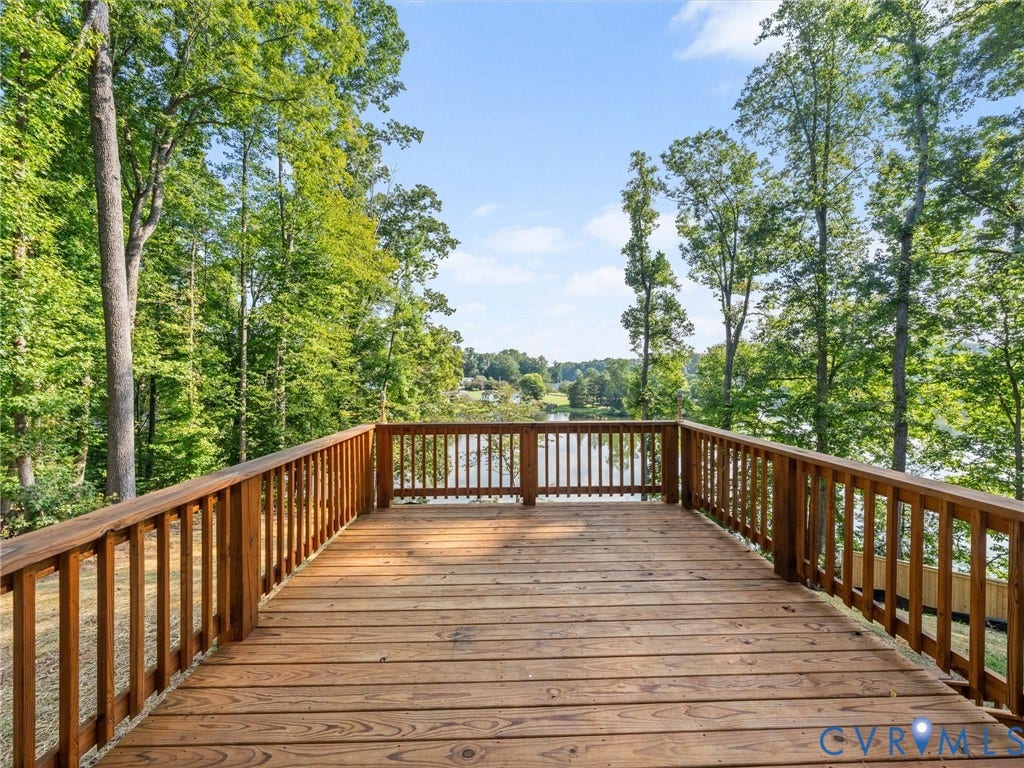 2224 Highland Drive, Powhatan, VA 23139 Wood deck with railing overlooking a body of water, surrounded by mature trees