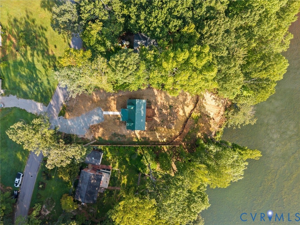 2224 Highland Drive, Powhatan, VA 23139 Aerial perspective featuring a property situated at the edge of a body of water, surrounded by mature trees, and accessed by a paved road