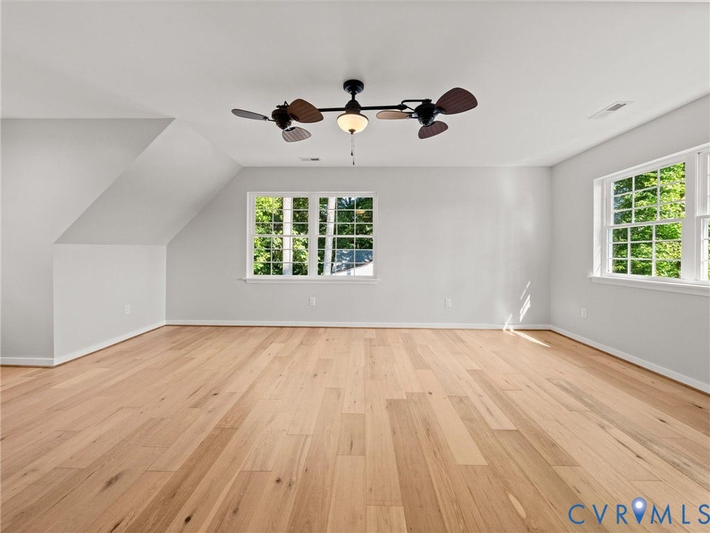 2224 Highland Drive, Powhatan, VA 23139 Bright interior space featuring wood-finish flooring, multiple windows, a ceiling fan with integrated lighting, and sloped ceiling details