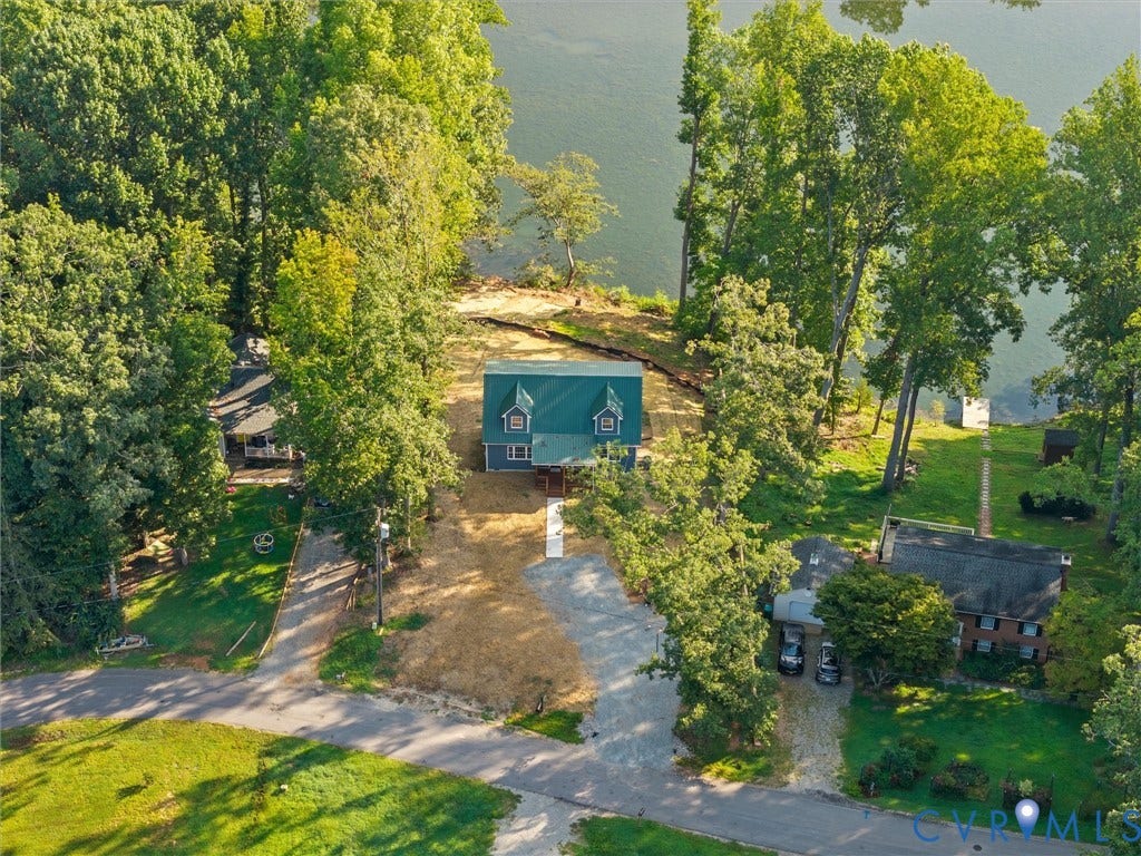 2224 Highland Drive, Powhatan, VA 23139 Waterfront property featuring a blue siding exterior, a green metal roof, and surrounding mature trees