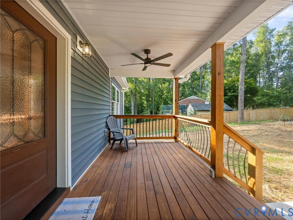 2224 Highland Drive, Powhatan, VA 23139 Covered front porch featuring wood-finish decking, dark gray siding, and a decorative glass-paneled entry door