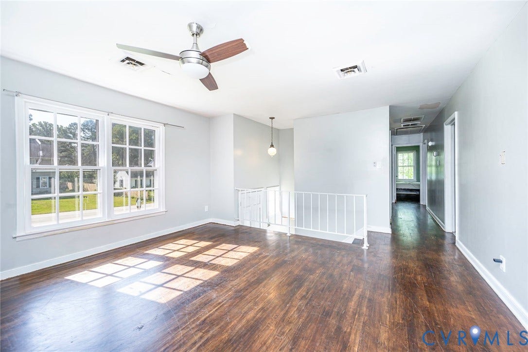 124 Northfield Lane, North Chesterfield, VA 23236 Expansive room featuring wood-finish flooring, large multi-pane windows, a ceiling fan, and a white railing