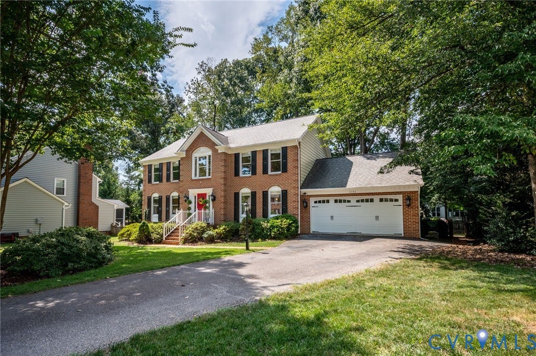 3704 Milbrier Place, Henrico, VA 23233 Brick colonial-style residence featuring a two-car garage, mature trees, and a paved driveway