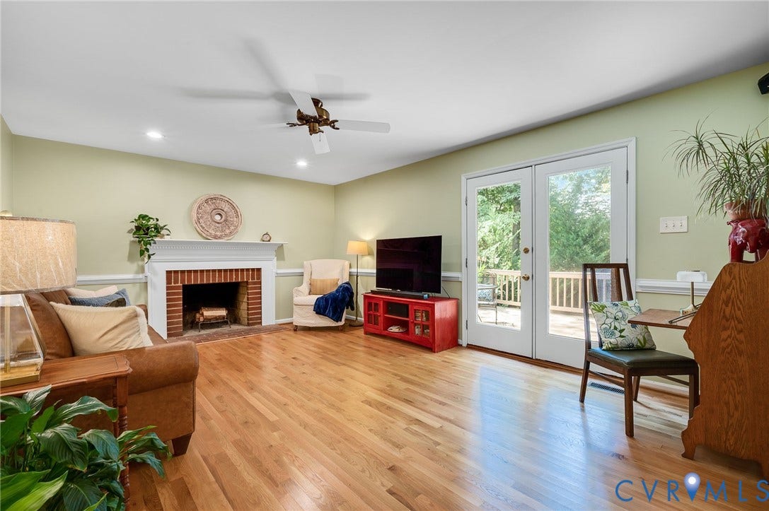 3704 Milbrier Place, Henrico, VA 23233 Hardwood flooring, brick-surround fireplace with mantel, recessed lighting, ceiling fan, and French doors leading to an exterior deck
