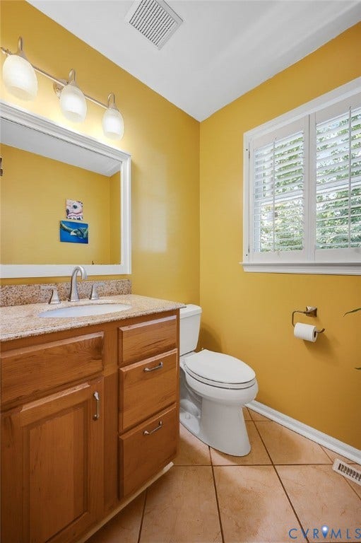 3704 Milbrier Place, Henrico, VA 23233 Vanity with wood-finish cabinetry, light-toned countertop, and undermount sink