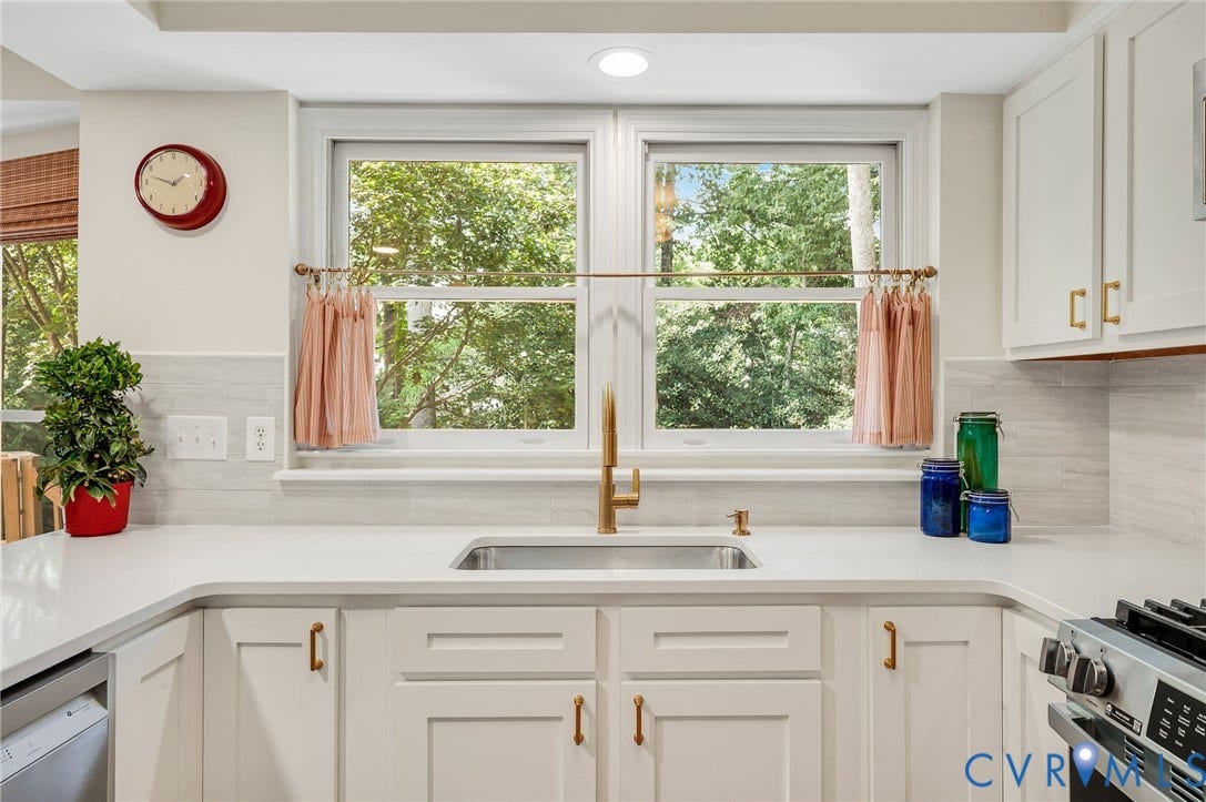 3704 Milbrier Place, Henrico, VA 23233 White shaker cabinetry with brass hardware, undermount stainless steel sink, gold-tone gooseneck faucet, light-toned countertop, and tile backsplash