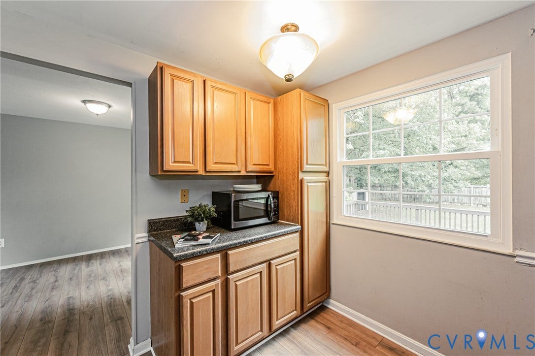 9406 Emmett Court, Glen Allen, VA 23060 Efficient kitchenette featuring warm wood-finish cabinetry, dark countertops, and built-in appliances