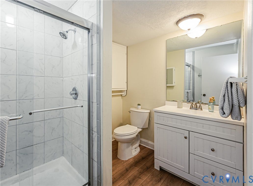 9406 Emmett Court, Glen Allen, VA 23060 Shower enclosure with clear glass door, white square tile surround, and chrome fixtures