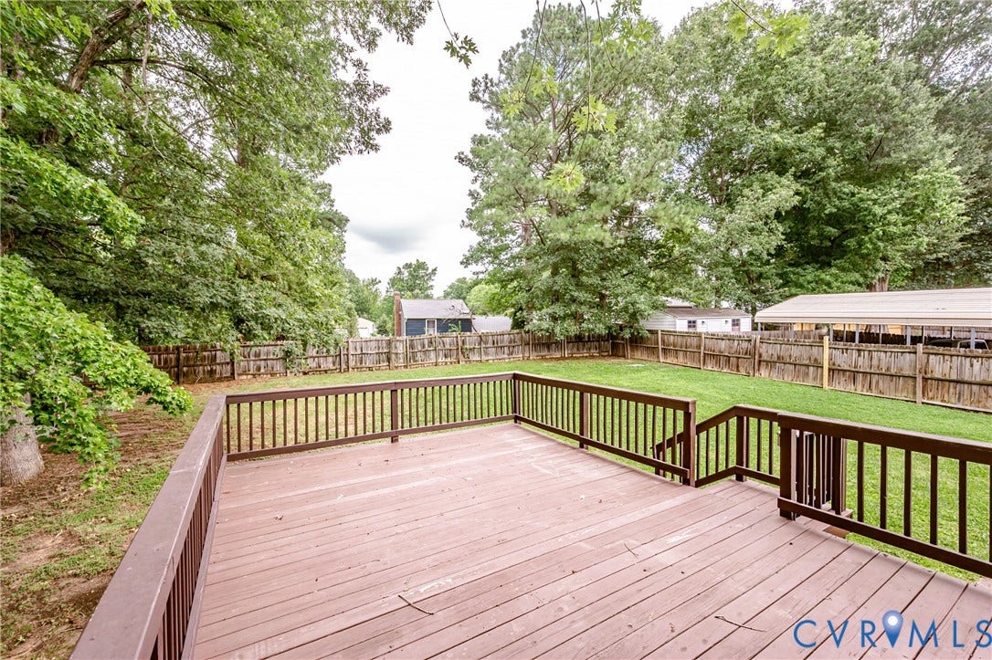 9406 Emmett Court, Glen Allen, VA 23060 Expansive composite deck featuring warm wood-finish decking and black aluminum railings, overlooking manicured grounds with mature tree-lined landscaping and fenced pasture areas ideal for equestrian or agricultural use