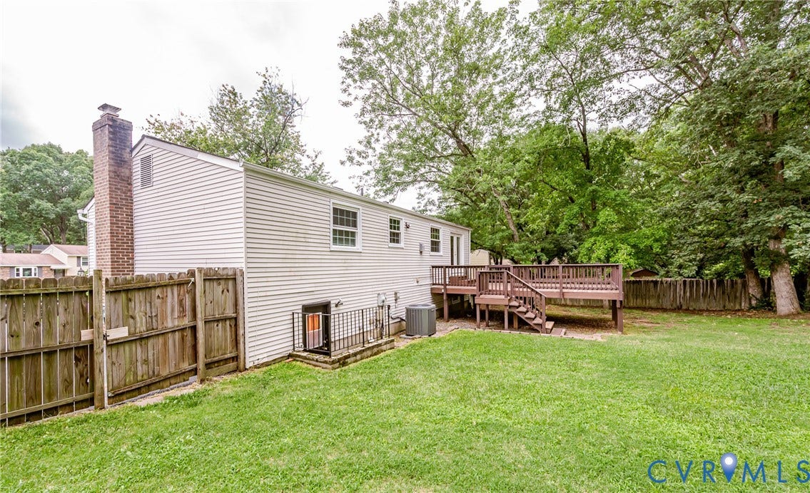 9406 Emmett Court, Glen Allen, VA 23060 Spacious backyard oasis featuring a manicured lawn, mature tree canopy, and wooden privacy fencing