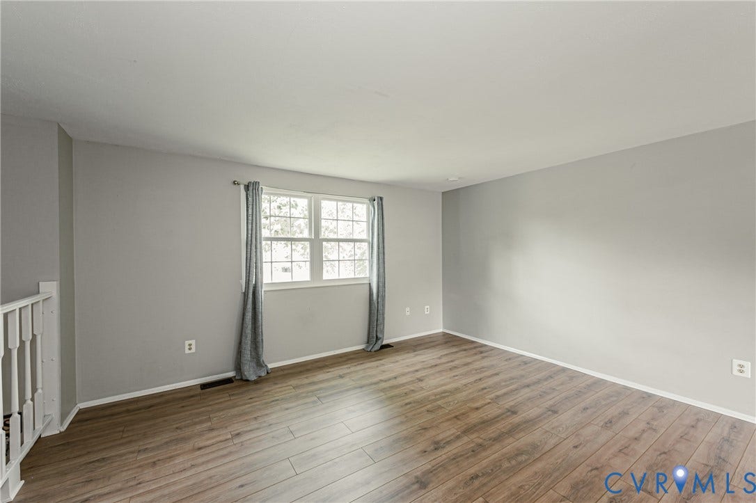 9406 Emmett Court, Glen Allen, VA 23060 Bright corner bedroom with expansive wood-finish flooring, large multi-pane windows providing natural light, and neutral wall finishes