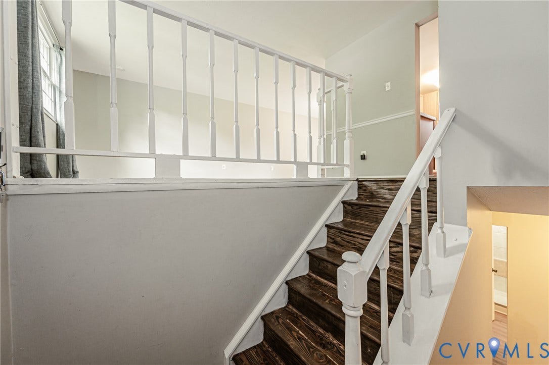 9406 Emmett Court, Glen Allen, VA 23060 Elegant staircase featuring dark wood-finish treads, white painted risers, and a white wooden handrail with vertical balusters