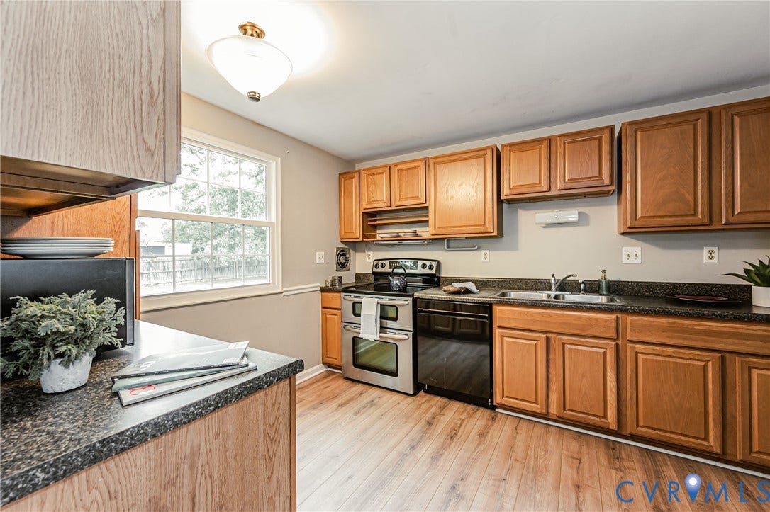 9406 Emmett Court, Glen Allen, VA 23060 Kitchen featuring wood-finish flooring, a double-basin stainless steel sink, black speckled countertops, and wood cabinetry