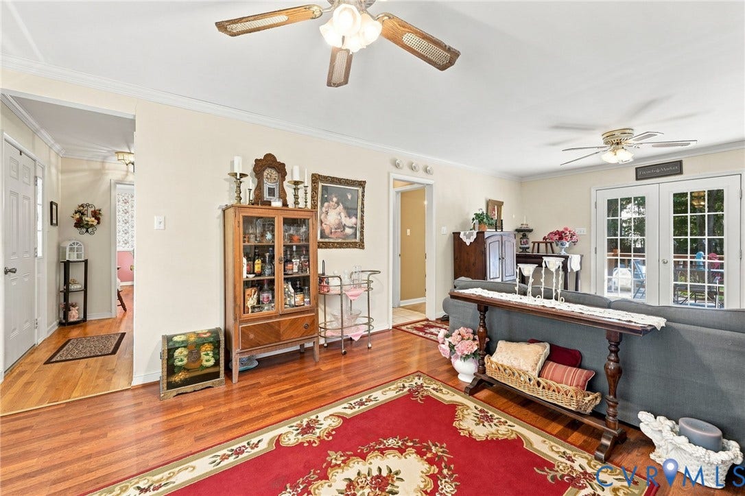 3819 Glen Oaks Court, Chester, VA 23831 Spacious living area featuring wood flooring, two ceiling fans with integrated lighting, and crown molding