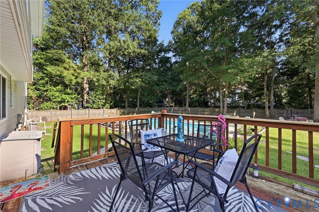 3819 Glen Oaks Court, Chester, VA 23831 Wood deck with baluster railing, featuring a pool and a fenced backyard with mature trees
