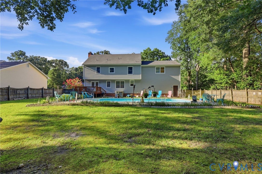 3819 Glen Oaks Court, Chester, VA 23831 Expansive grassy backyard featuring an in-ground swimming pool, a multi-level wooden deck, and mature perimeter trees