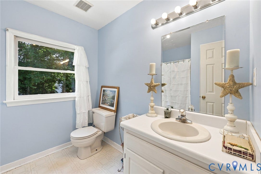 3819 Glen Oaks Court, Chester, VA 23831 Bathroom featuring a single-sink vanity with an integrated basin, a wall-mounted mirror, and a window with white trim
