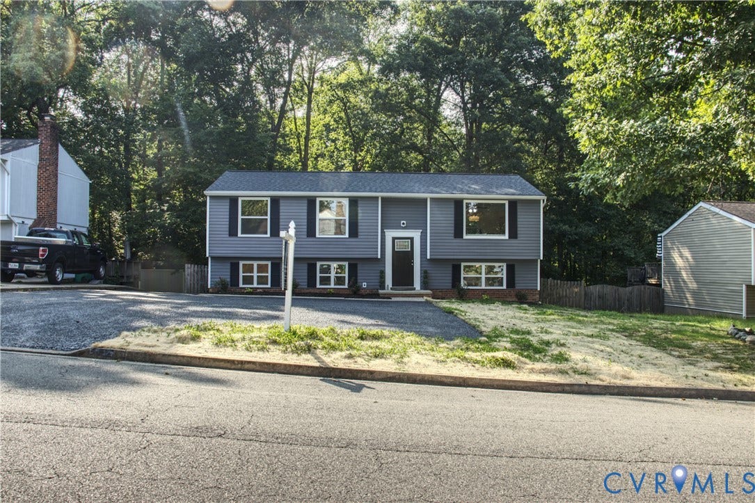 5004 Fairlake Lane, Henrico, VA 23060 Split-level residence featuring gray siding with black shutters, a dark entry door, and a gravel driveway