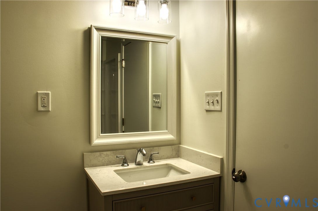 5004 Fairlake Lane, Henrico, VA 23060 Bathroom vanity featuring a framed mirror, a countertop with an integrated sink, and a chrome faucet
